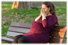 Pregnant woman sitting on park bench